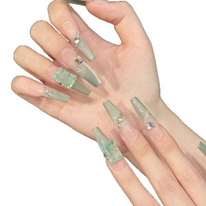 Long coffin press-on nails with mint green cat eye effect, 3D butterfly, and rhinestones