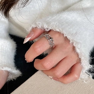 Detailed view of silver triple-layered star ring with zircon inlay on model's finger
