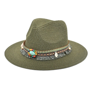Detail of woven straw hat with turquoise stone, colorful wood beads and grey fringe