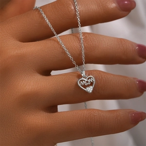 Detail of S925 silver heart necklace with MOM lettering and a small diamond pendant