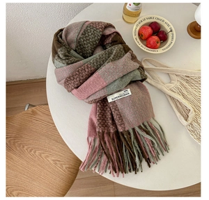 Close-up of pink and brown plaid scarf with fringe and a fashion label on a table