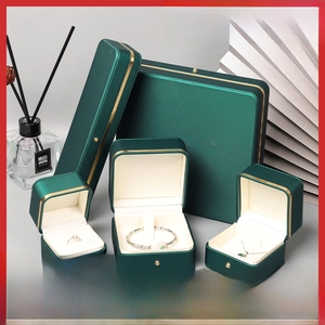 Deep green jewelry gift box set with gold trim and cream velvet interior lining