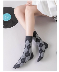 Detailed view of gray diamond pattern cotton socks on model with minimalist backdrop