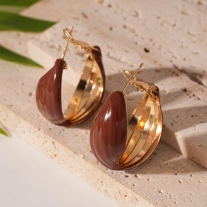 Macro view of vintage geometric drop earrings with dark red enamel and gold plating