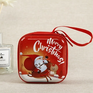 Close-up of red Christmas tin coin purse with cartoon Santa and reindeer design