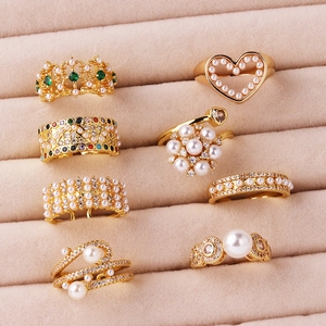 Detailed view of eight gold-plated fashion rings with pearls and colorful zircons