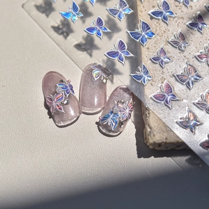 Macro detail of laser holographic 3D butterfly nail art stickers with iridescent texture
