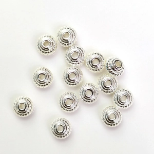 Zilveren spiraalvormige afstandskralen voor DIY sieraden op een witte achtergrond
