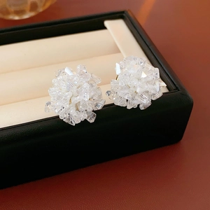 Detailed view of clear crystal bead cluster floral earrings on a jewelry display pad