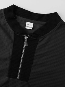 Detail of quarter-zip collar and waffle texture on a men's polyester sports suit