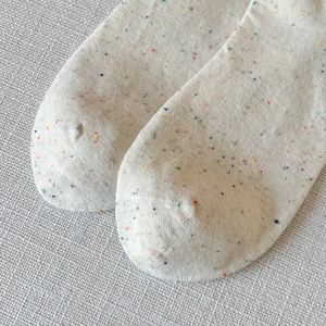 Close-up of confetti knit cotton socks with colorful dots and fine texture details
