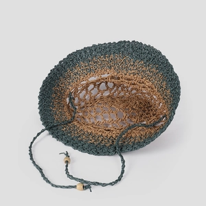 Detail of hand-woven straw hat with mesh crown and wooden bead tassels in two-tone design