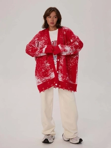 Red Christmas oversized knit cardigan with white splatter pattern and distressed hem