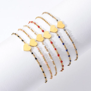 Detail of six colorful beaded heart bracelets on a white cylinder display stand