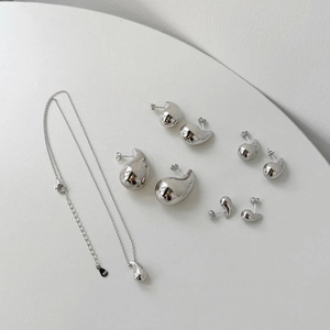 Minimalist 925 sterling silver set featuring a teardrop necklace and four pairs of stud earrings