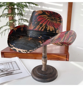 Détail d'un chapeau de cow-boy en paille tressée avec motif d'étoiles rouges et noires