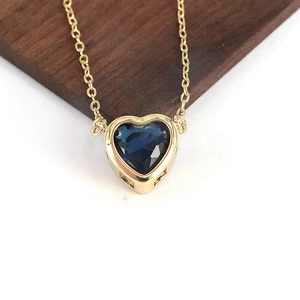 Dettaglio del ciondolo a cuore in zaffiro blu su una catena a onde dorata fine