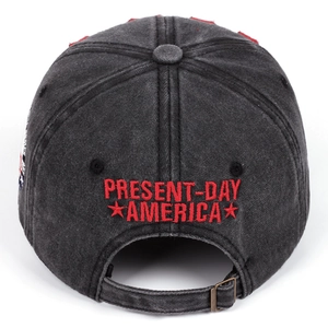 Detail of vintage washed black cap featuring red embroidery and bronze metal adjustment buckle