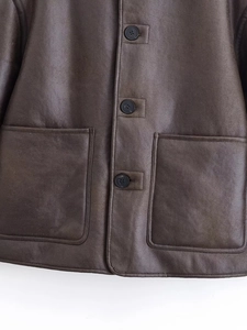 Close-up of deep brown leather jacket featuring black round buttons and large pockets