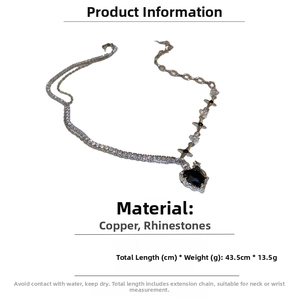 Detailed view of silver layered necklace with black heart pendant and rhinestones