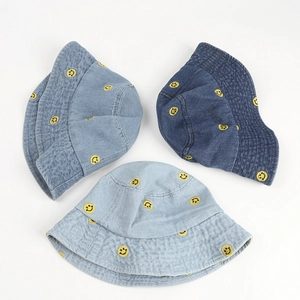 Denim bucket hats with embroidered yellow smiley faces in dark, medium, and light blue wash