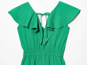 Detailed view of green V-neck ruffle romper with back tie and elastic waist stitching
