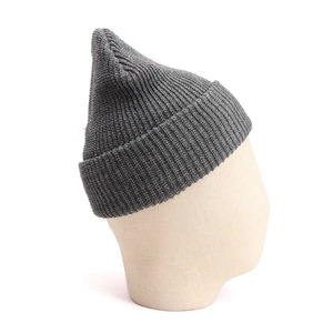 Detail shot of a dark grey chunky knit beanie with cuffed brim on a display head