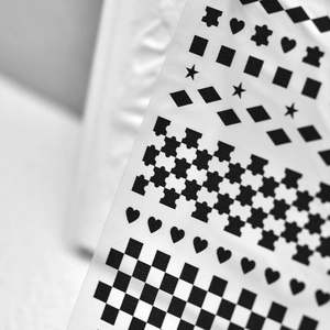 Detail shot of black geometric nail stickers with hearts, stars and checkered patterns