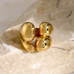 Macro view of 18k gold plated stainless steel double layer ring on textured stone base