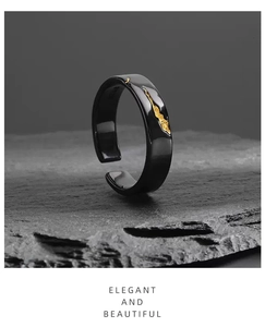 Detail of creative black and gold ring with golden texture on a stone surface