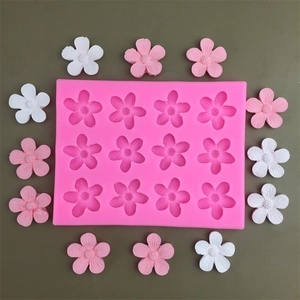 Pink silicone mold with 12 flower cavities and finished white and pink resin flowers