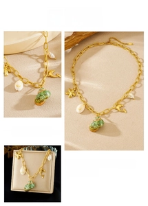 Detail of gold ocean necklace with shell, starfish and green conch pendant charms
