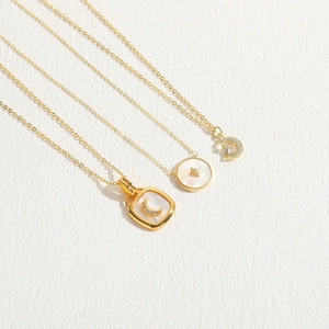 Elegant 14K gold plated necklaces with shell star and moon pendants on white leather