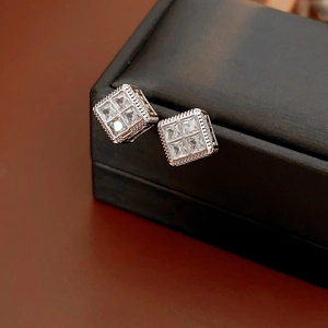 Gros plan de boucles d'oreilles carrées en zircon avec texture perlée sur coffret