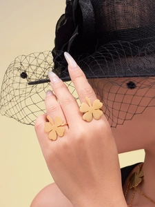 Detail of 18k gold plated four-leaf clover rings worn by a model with elegant styling
