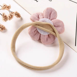 Détail d'un bandeau pour bébé avec fleur en tissu rose et bande élastique en nylon
