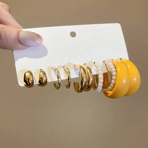 Detailed view of 6-pair gold and yellow acrylic earring set with pearl accents