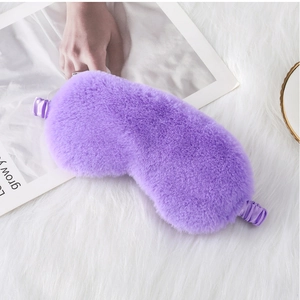 Close-up of soft purple plush sleep mask with satin elastic strap on white faux fur