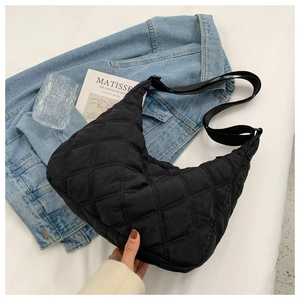 Detail of black quilted crescent crossbody bag with adjustable wide shoulder strap