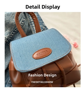 Dettaglio della patta in denim blu e pelle marrone su questo zaino elegante da donna