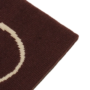 Macro detail of dark brown knit beanie showing fine stitching and beige curved pattern