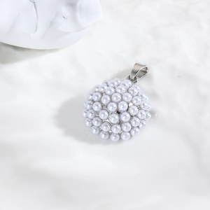 Vue macro d'un pendentif perle blanche sphérique avec fermoir métallique sur fond blanc