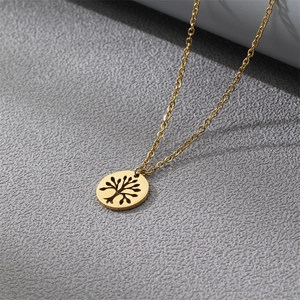 Gold stainless steel Tree of Life pendant necklace with an O-chain on textured background
