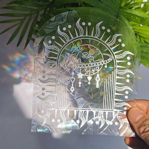 Close-up of holographic suncatcher sticker casting a vibrant rainbow shadow on wall