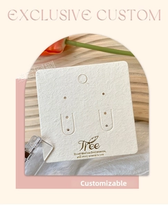 Detailed view of custom white jewelry card with gold logo and cutouts for earrings