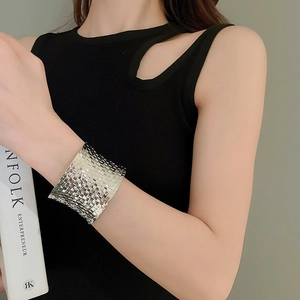 Detailed view of silver woven metal wide cuff bracelet on model featuring textured pattern