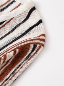 Detail of hollow crochet knit texture with striped pattern in beige, black and caramel