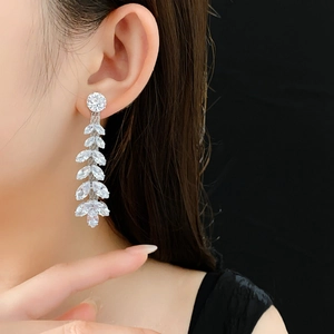Detail of silver long tassel earrings with leaf-shaped sparkling cubic zirconia crystals