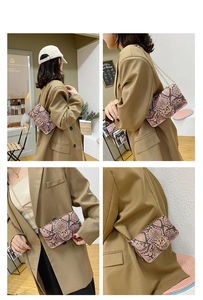 Detail of pink snakeskin pattern crossbody bag with gold chain and metal buckle decoration