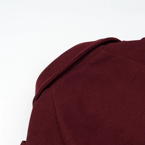 Detail shot of wine red wool coat shoulder showing stitching and fabric texture